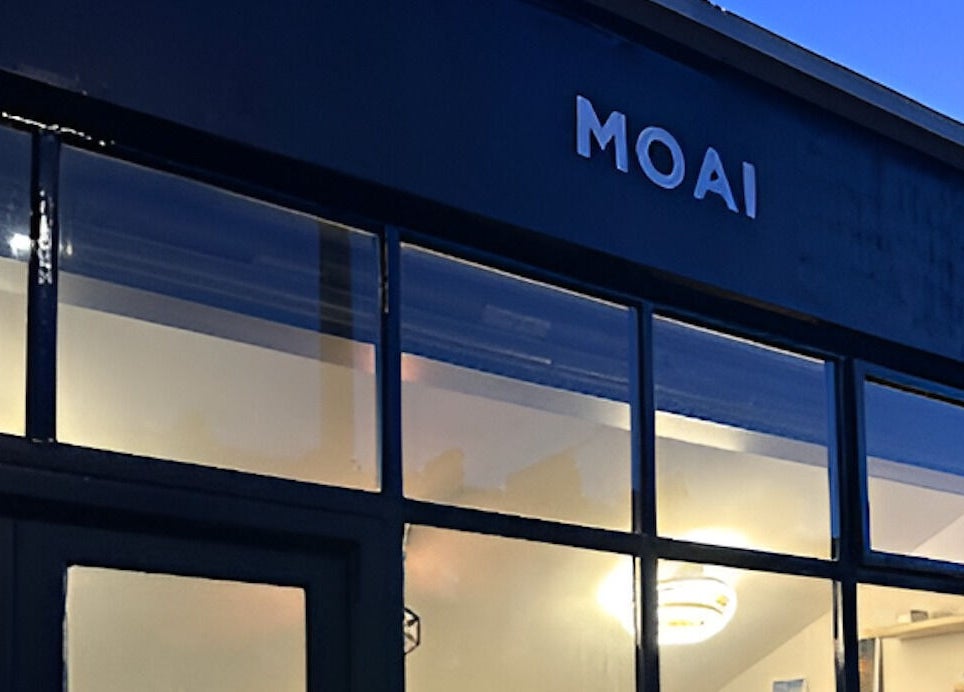 MOAI Barber Studio exterior at dusk, London, England, GB, warmly lit windows.