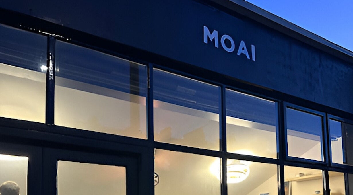 MOAI Barber Studio exterior at dusk, London, England, GB, warmly lit windows.
