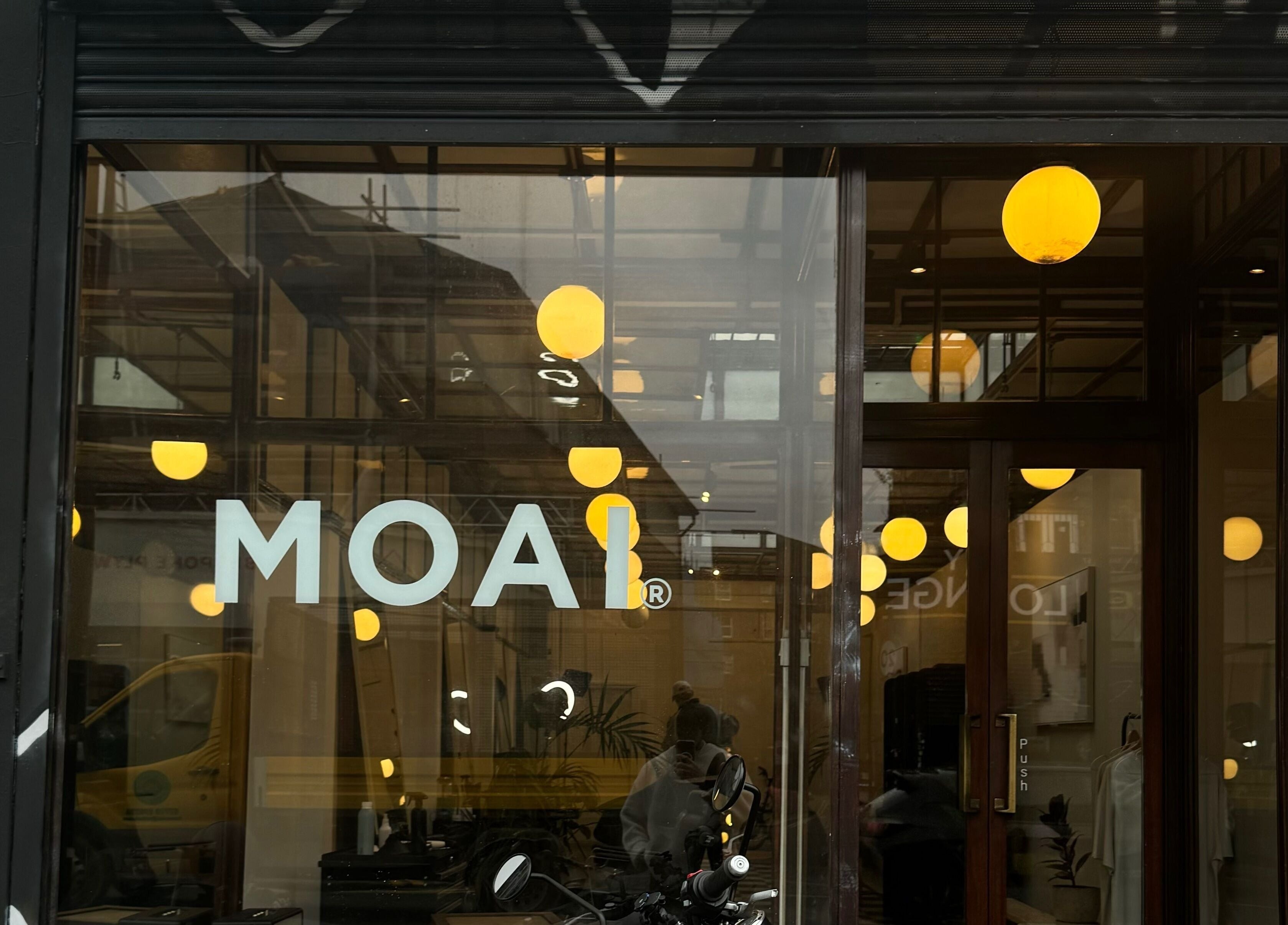 Front view of MOAI Barber Studio in London, England, GB with modern glass design and warm lighting.
