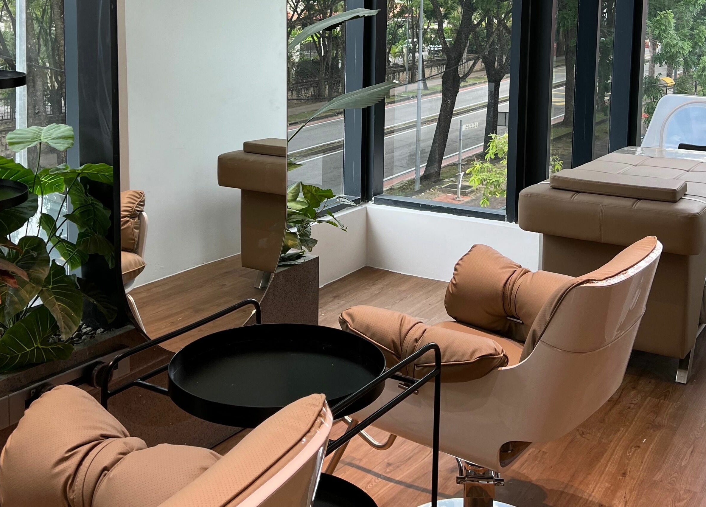 Tranquil salon seating at Hair Library in Petaling Jaya, Selangor, MY with lush greenery and natural light.