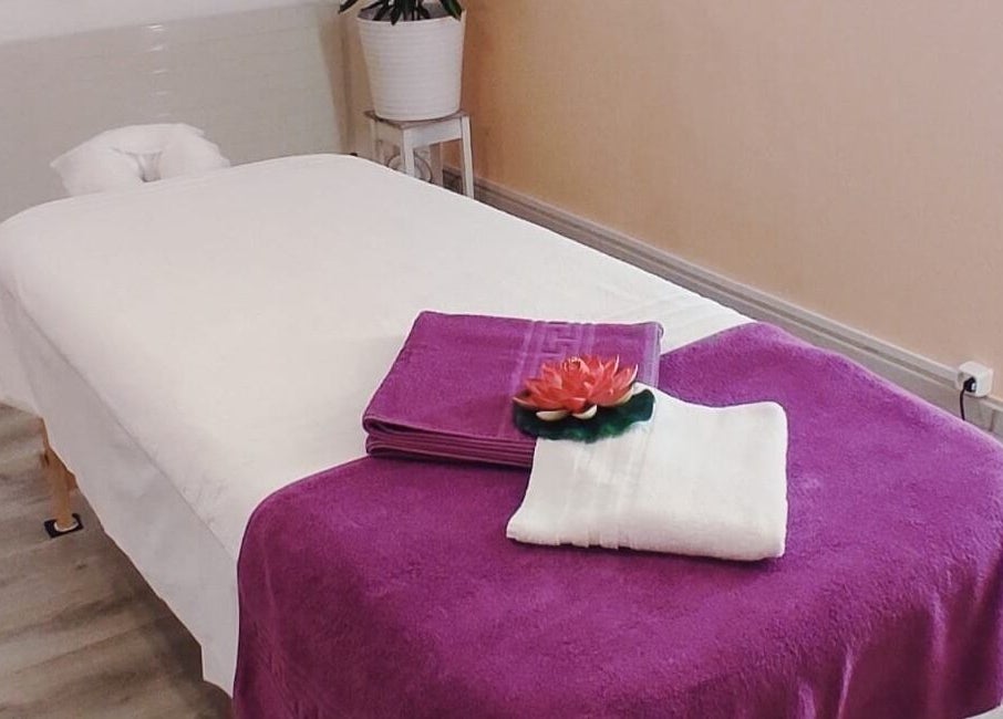 Gemütlicher Massagetisch bei Yanisa Massage, Basel, Basel-stadt, CH. Lila Handtuch und Lotusdeko.