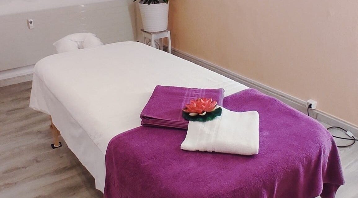 Gemütlicher Massagetisch bei Yanisa Massage, Basel, Basel-stadt, CH. Lila Handtuch und Lotusdeko.