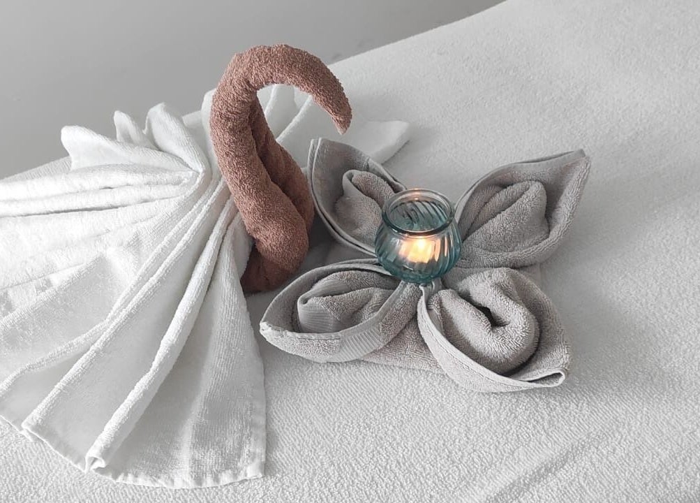 Handtuchschwan und Kerze bei Yanisa Massage in Basel, Basel-stadt, CH auf einem Massagebett.