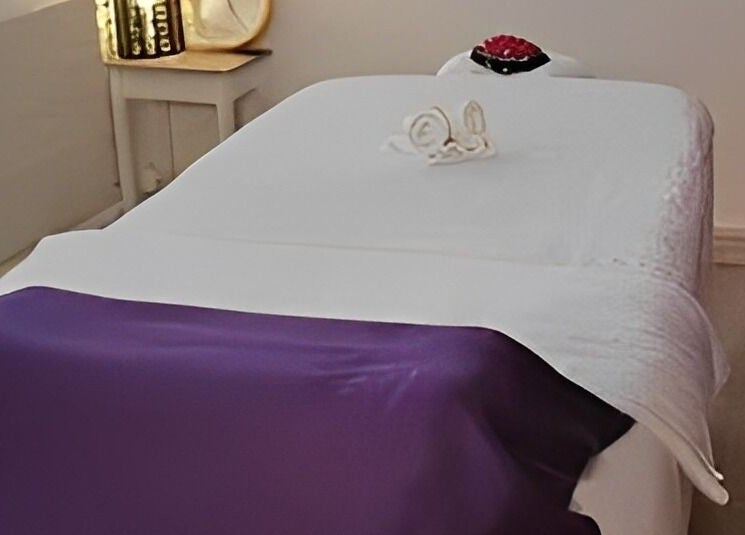 Massagebett bei Yanisa Massage, Basel, Basel-stadt, CH, mit lila Decke für totale Entspannung.