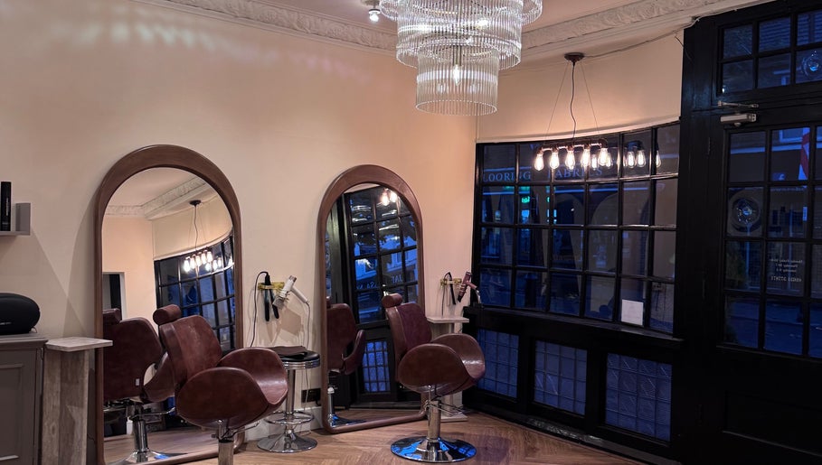 Elegant interior of FiftyEight Hair Design with mirrors and chairs in Gillingham, England, GB.
