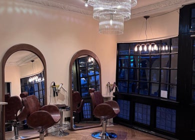 Elegant interior of FiftyEight Hair Design with mirrors and chairs in Gillingham, England, GB.