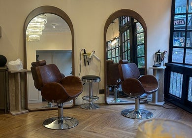 Elegant interior of FiftyEight Hair Design in Gillingham, England, GB, showcasing chic salon chairs and mirrors.