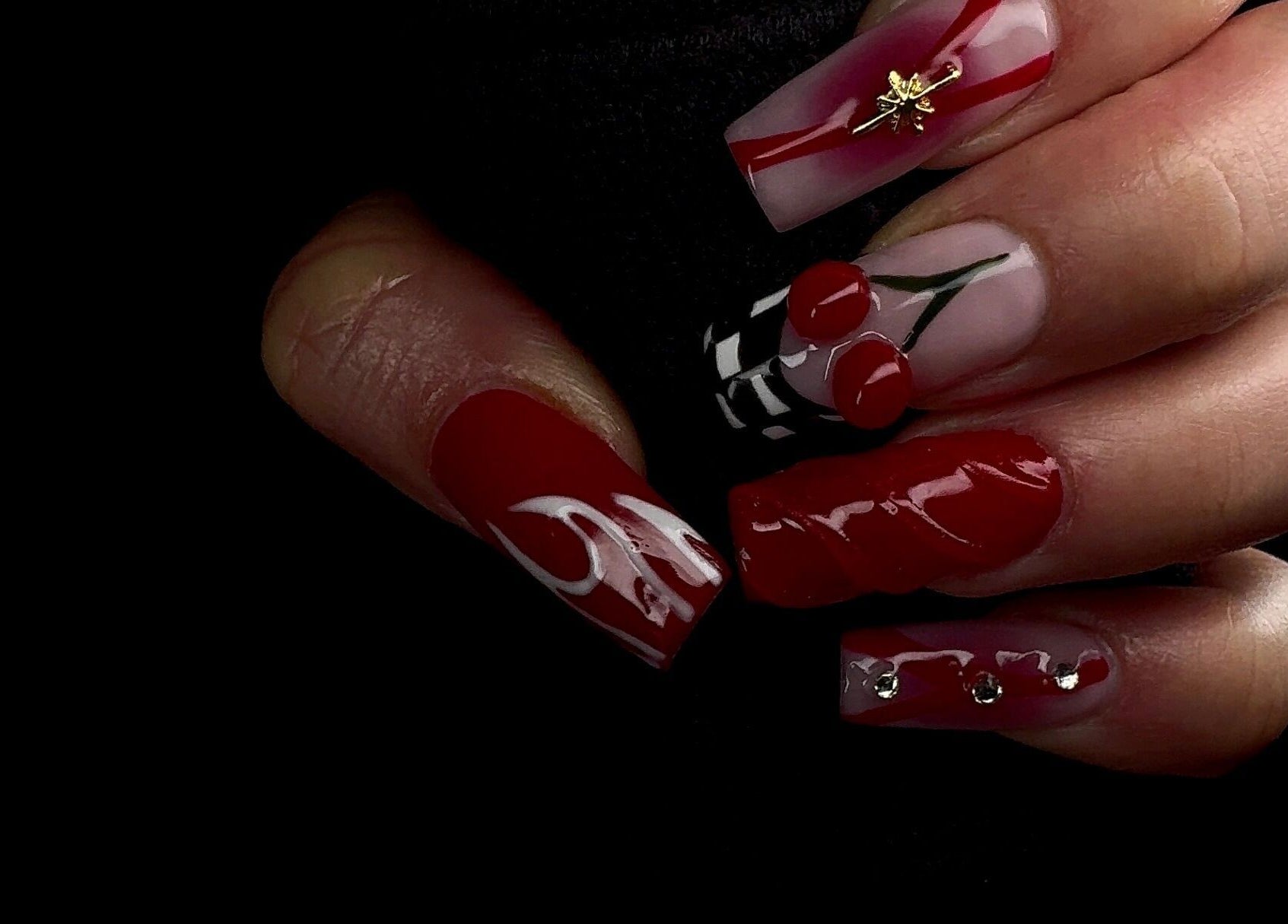 Nail art créatif et audacieux à Studio Nipawan, Montréal, Québec, CA. Design rouge avec motifs cerise.