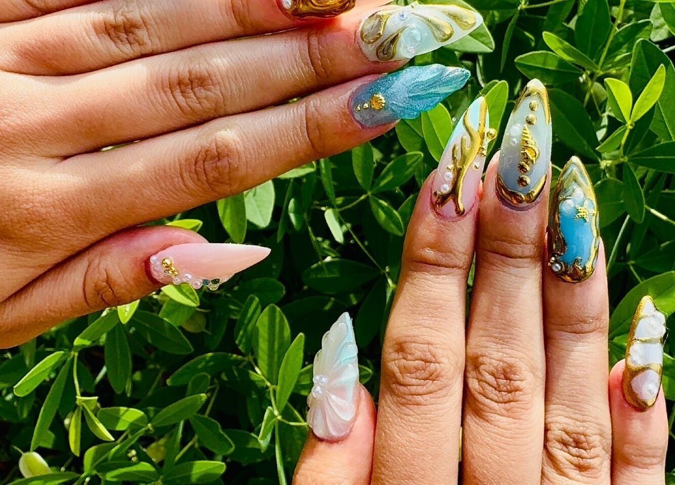 Nail art brillant à Studio Nipawan, Montréal, Québec, CA avec des motifs dorés raffinés.