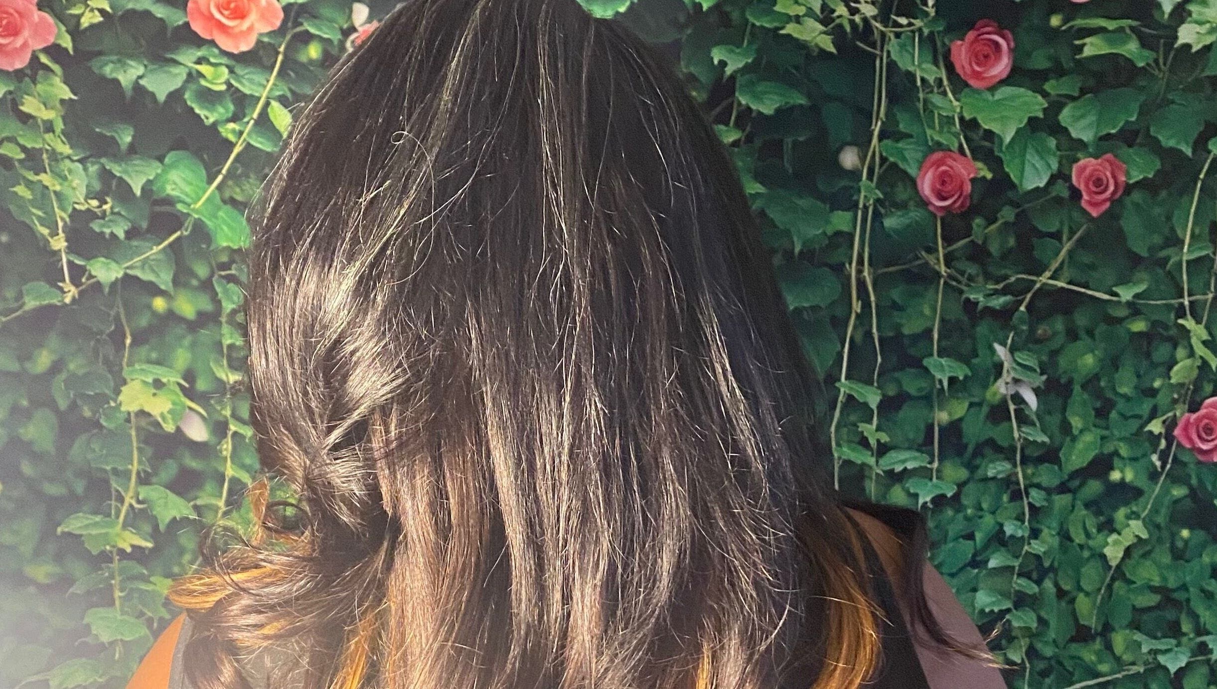 Elegant styled hair at Rich Girlz Hair Studio, Houston, Texas with rose backdrop.