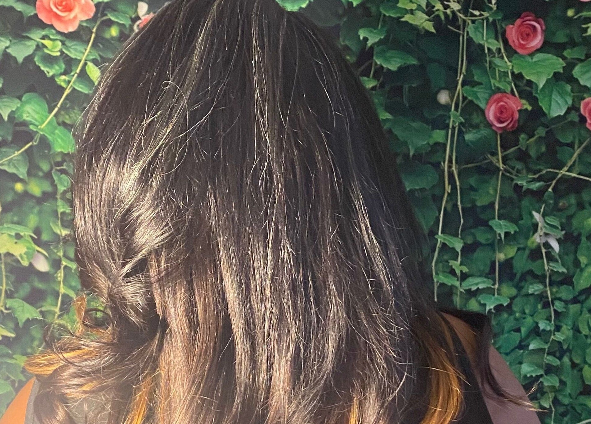 Elegant styled hair at Rich Girlz Hair Studio, Houston, Texas with rose backdrop.