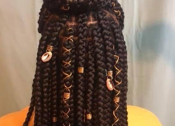 Intricate braided hairstyle with beads at Rich Girlz Hair Studio, Houston, Texas, US.