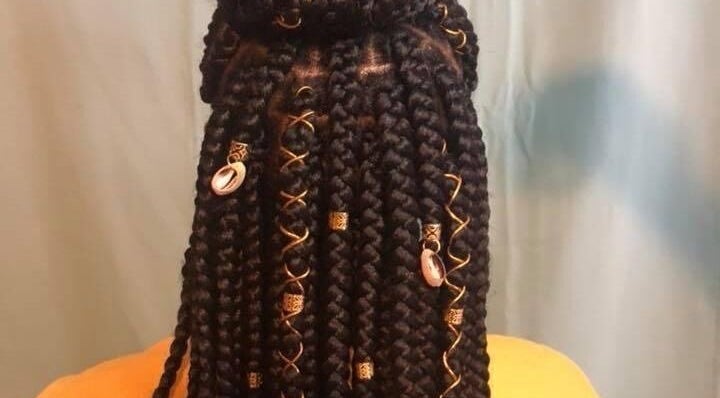 Intricate braided hairstyle with beads at Rich Girlz Hair Studio, Houston, Texas, US.