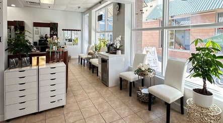 Bright waiting area of Act II Salon in Fairfax, Virginia, US with elegant seating and lush plants.