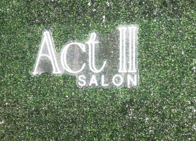 Illuminated Act II Salon sign on lush greenery wall, Fairfax, Virginia, US.