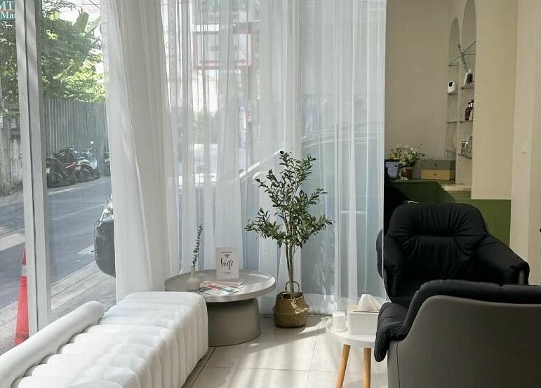 Cozy, modern seating area in Haho Hair, Krung Thep Maha Nakhon, with natural light streaming in through large windows.
