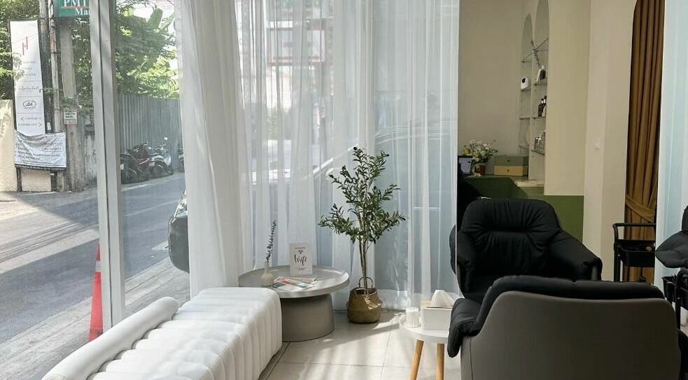 Cozy, modern seating area in Haho Hair, Krung Thep Maha Nakhon, with natural light streaming in through large windows.