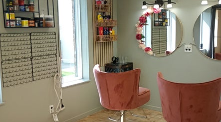 Intérieur élégant de Tresse Xtension & Beauty à Shawinigan, Québec, avec fauteuil rose et miroir décoré.