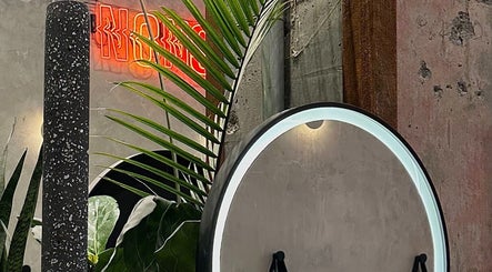 Modern decor at Nonstop Style 33 in New York, New York, US, featuring a round mirror and vibrant neon sign.