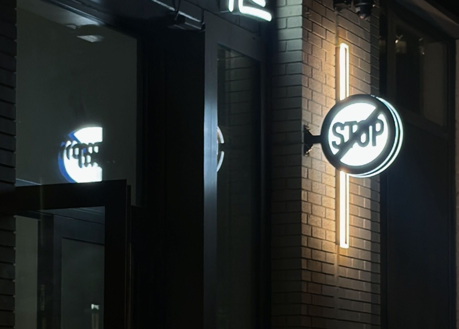 Illuminated signage at Nonstop Style LIC, New York, New York, US. A vibrant night scene.
