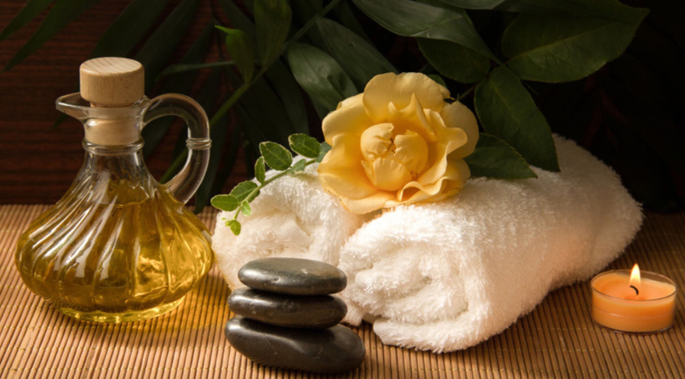 Calming spa essentials at iRis, Taunggyi, Shan State, MM, showcasing towels, oil, stones, and a candle.