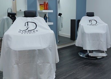 Interior of José J&DBarbers Studio, Manchester, England, with stylish barber chairs and products.