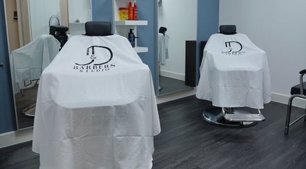 Interior of José J&DBarbers Studio, Manchester, England, with stylish barber chairs and products.