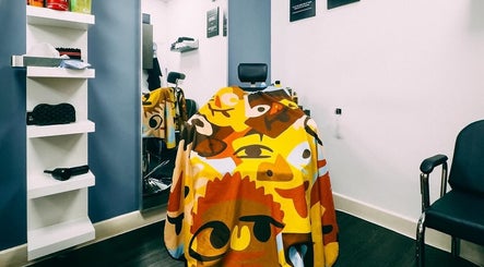 Colorful styling chair at José J&DBarbers Studio, Manchester, England, GB with artistic cape design.