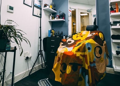 Vibrant barber chair setup at José J&DBarbers Studio in Manchester, England, GB, with colorful artwork decor.