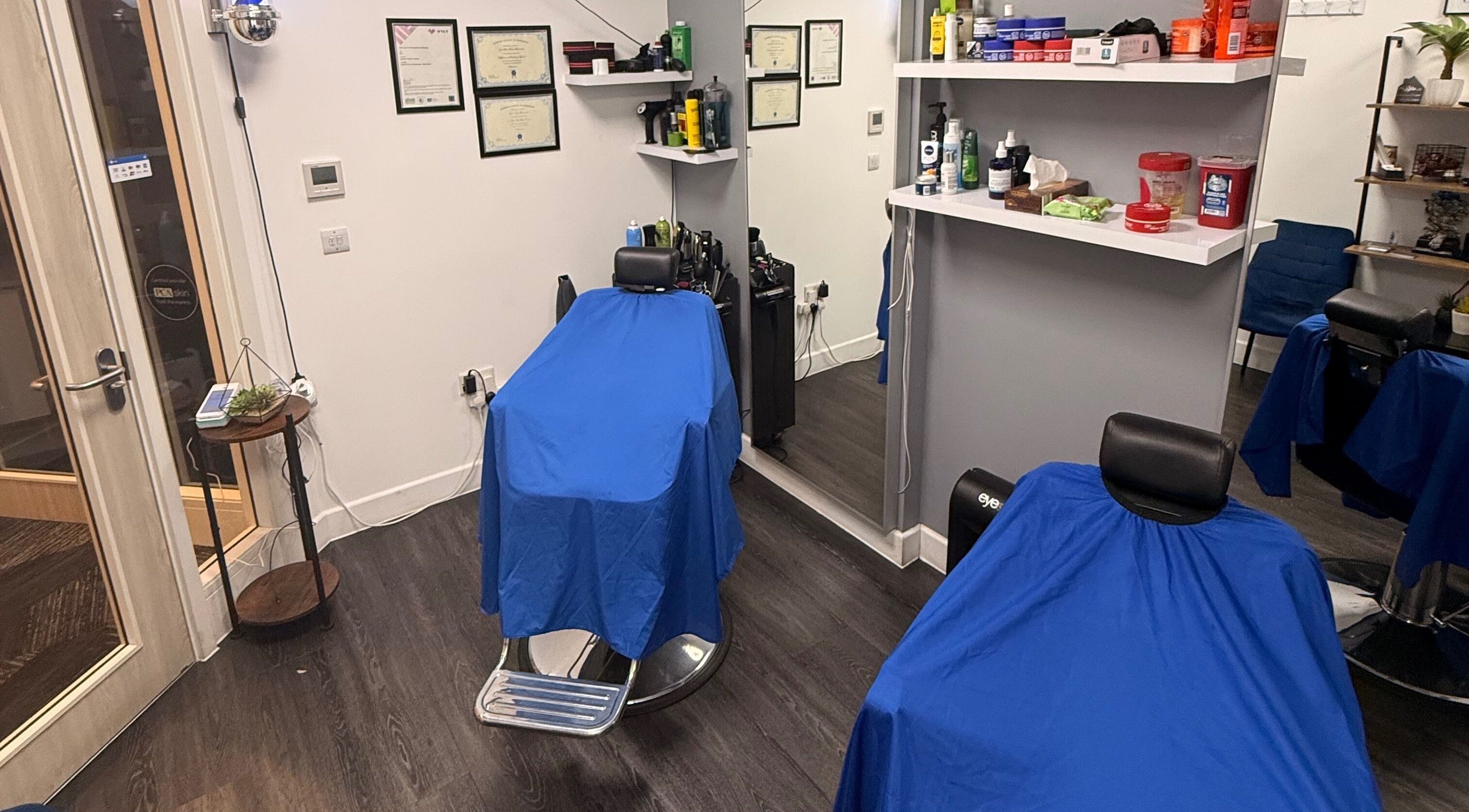 Interior of José J&DBarbers Studio in Manchester, England, GB featuring barber chairs and grooming products.