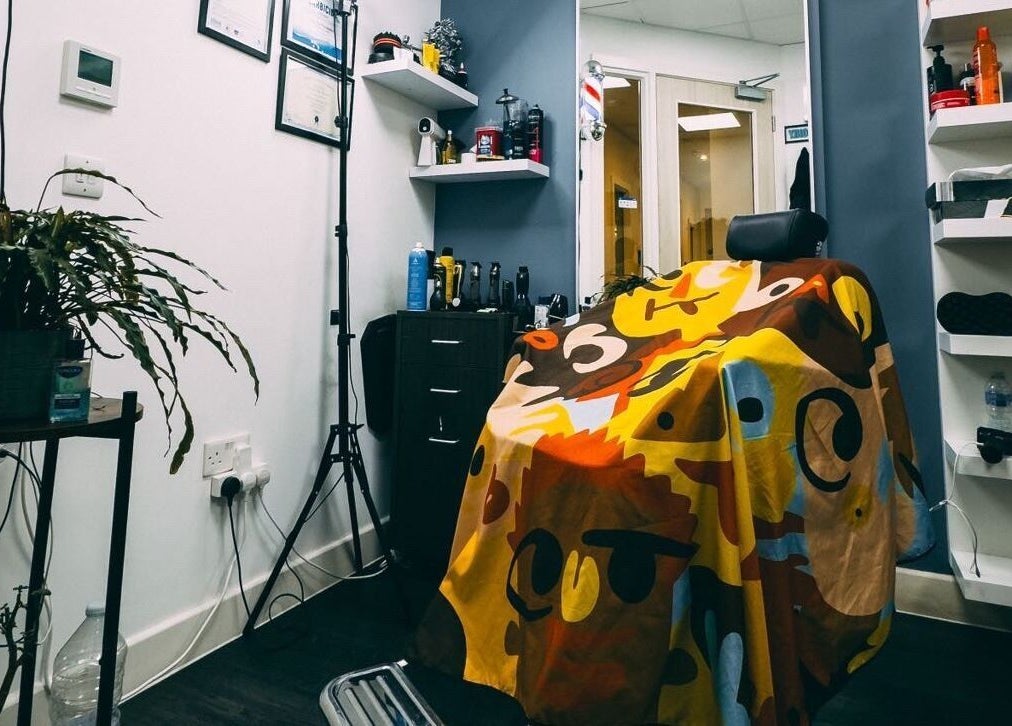 Vibrant barber chair at José J&DBarbers Studio, Manchester, England, GB. Stylish decor and grooming products visible.