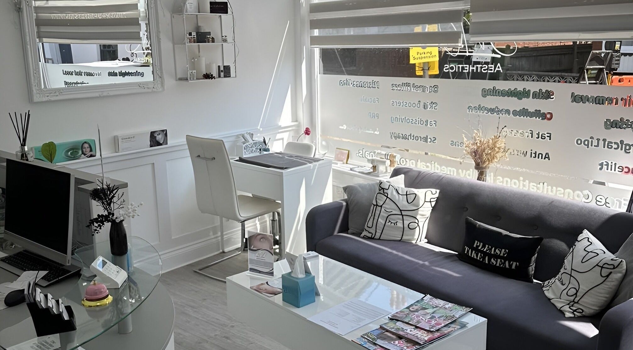 Modern reception area at Jnc Aesthetics in Eastbourne, England, GB with stylish seating and decor.