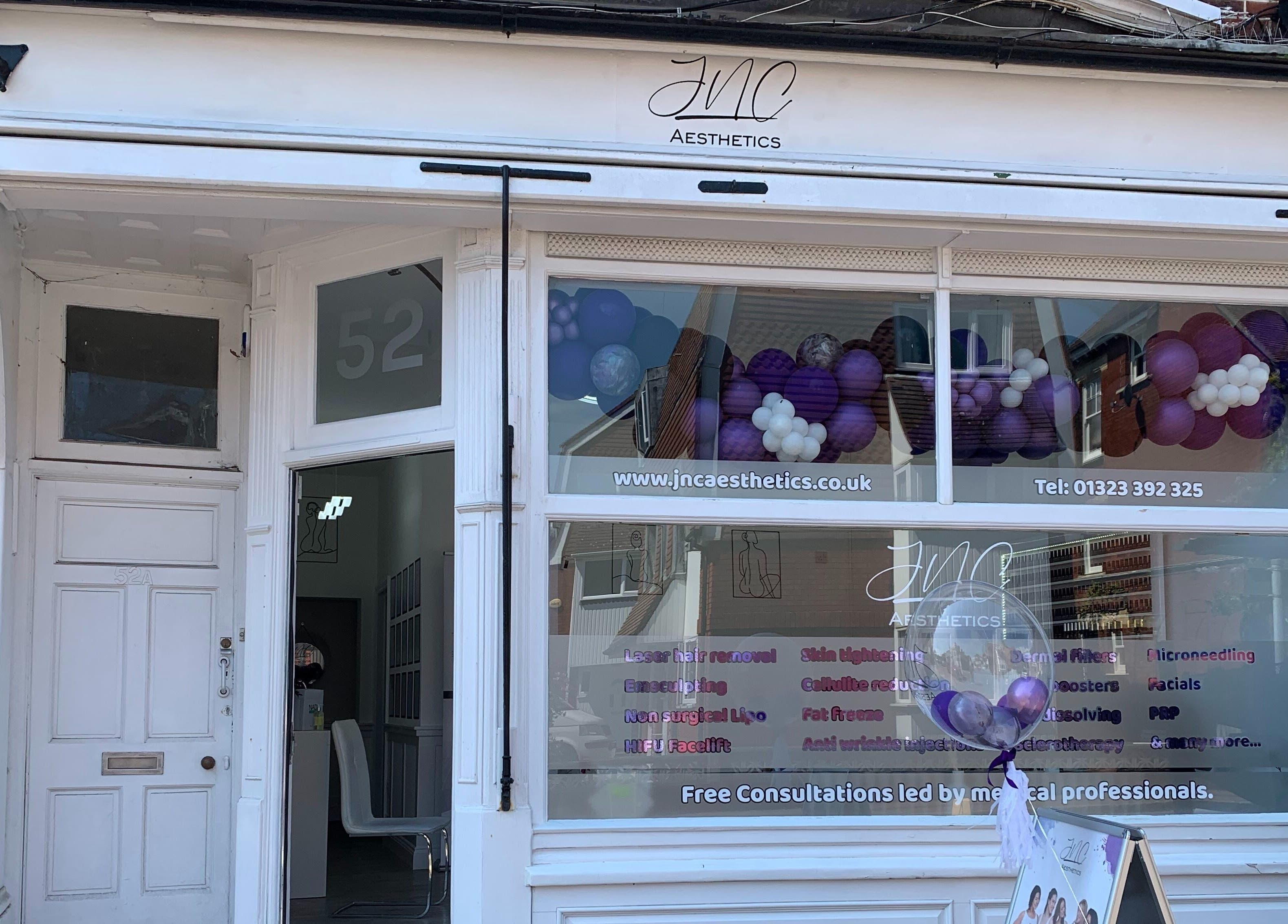 Front view of Jnc Aesthetics, Eastbourne, England, GB, featuring elegant white storefront with branding.
