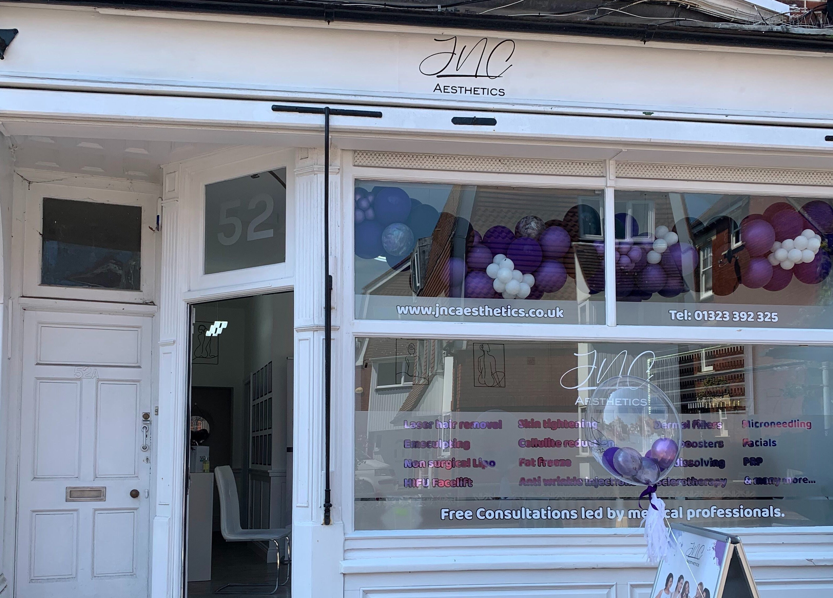 Front view of Jnc Aesthetics, Eastbourne, England, GB, featuring elegant white storefront with branding.