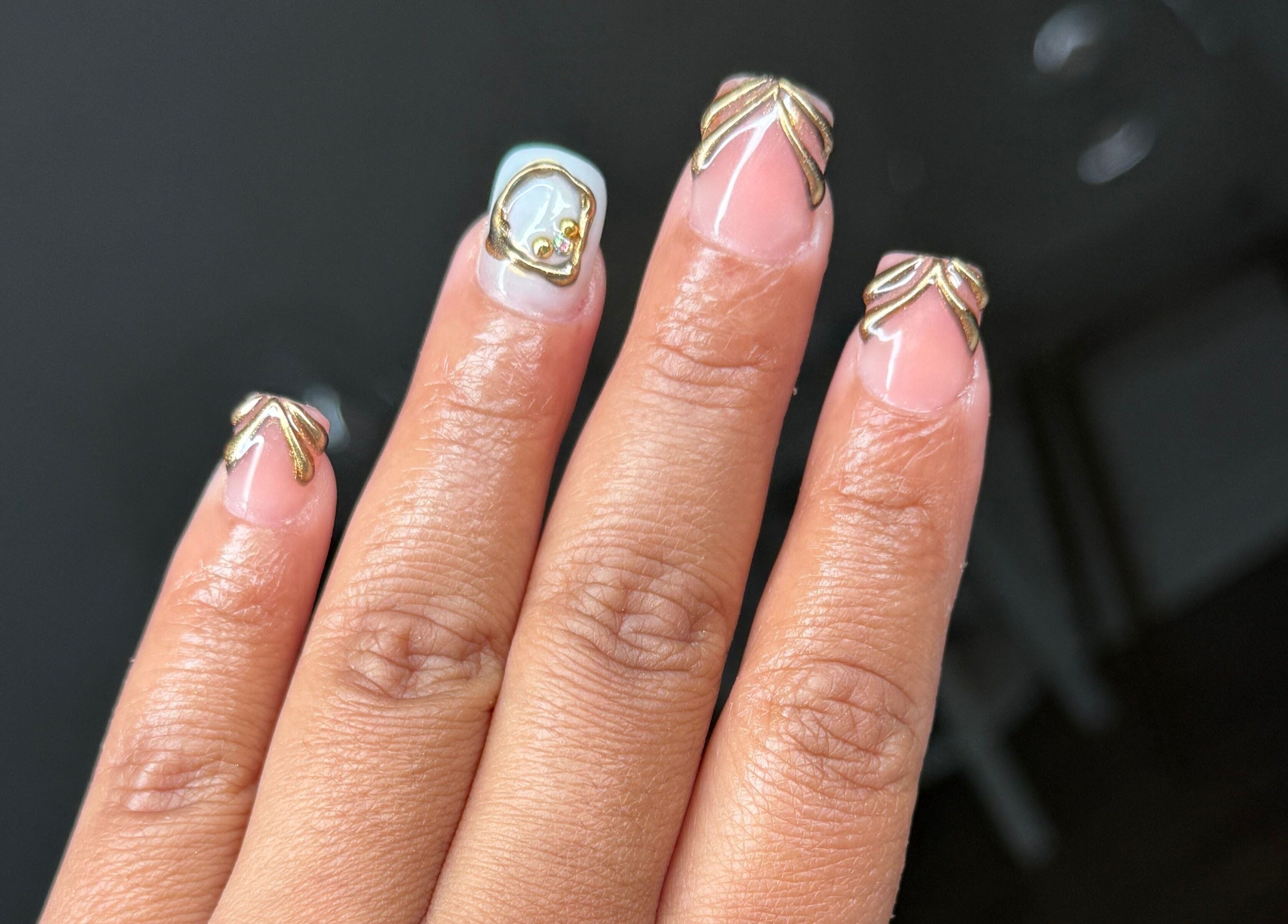 Uñas con diseño dorado en Ulis Studio Lashes Brows LLC, Lexington, Kentucky, US.