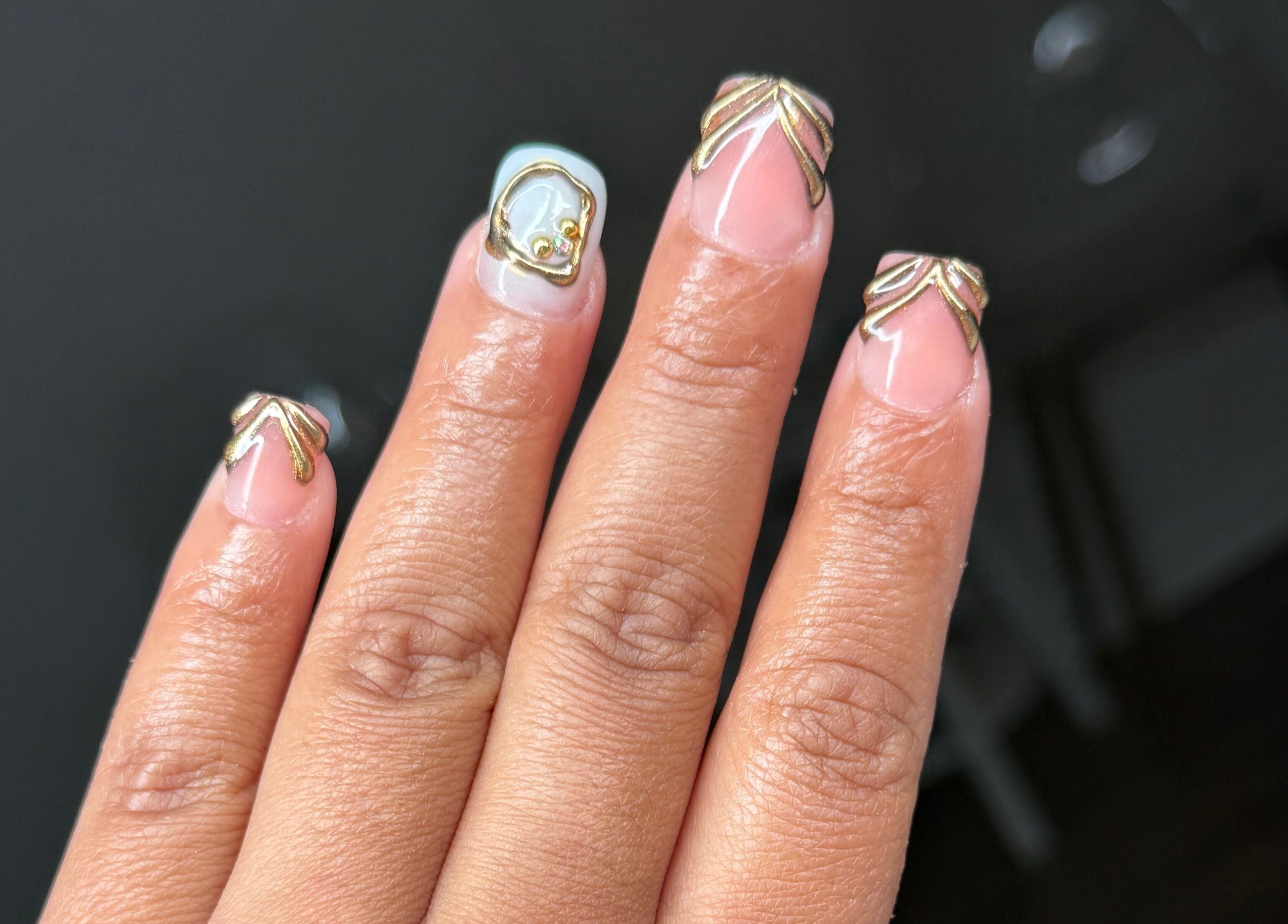 Uñas con diseño dorado en Ulis Studio Lashes Brows LLC, Lexington, Kentucky, US.