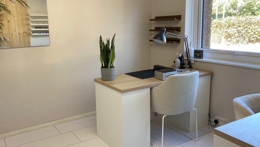 Modern, light-filled workspace at Preen in Edinburgh, Scotland, GB, featuring a sleek desk with a plant.
