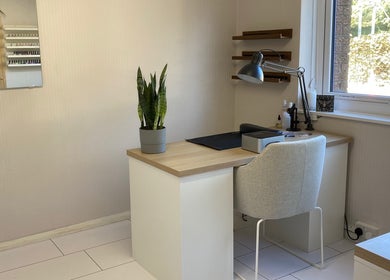 Modern, light-filled workspace at Preen in Edinburgh, Scotland, GB, featuring a sleek desk with a plant.