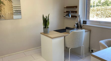 Modern, light-filled workspace at Preen in Edinburgh, Scotland, GB, featuring a sleek desk with a plant.