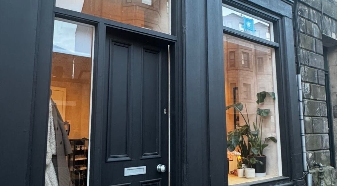 Charming black storefront of Preen in Edinburgh, Scotland, GB with plants in window.