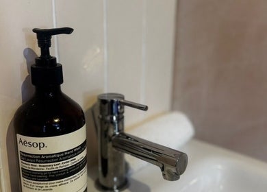 Aesop soap beside a sleek faucet at Preen, Edinburgh, Scotland, GB, emitting luxury and cleanliness.