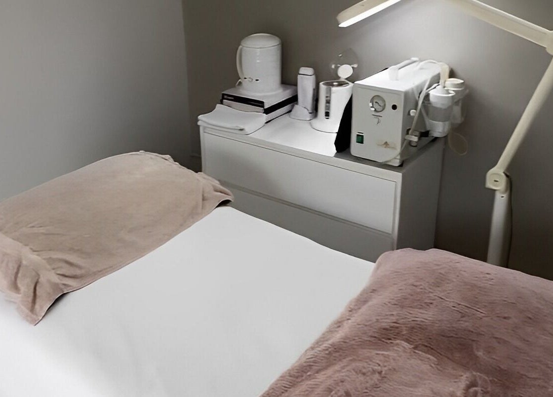 Relaxing treatment room at Aesthetics by Des, Cambridge, Waikato, NZ, with spa essentials and cozy bedding.