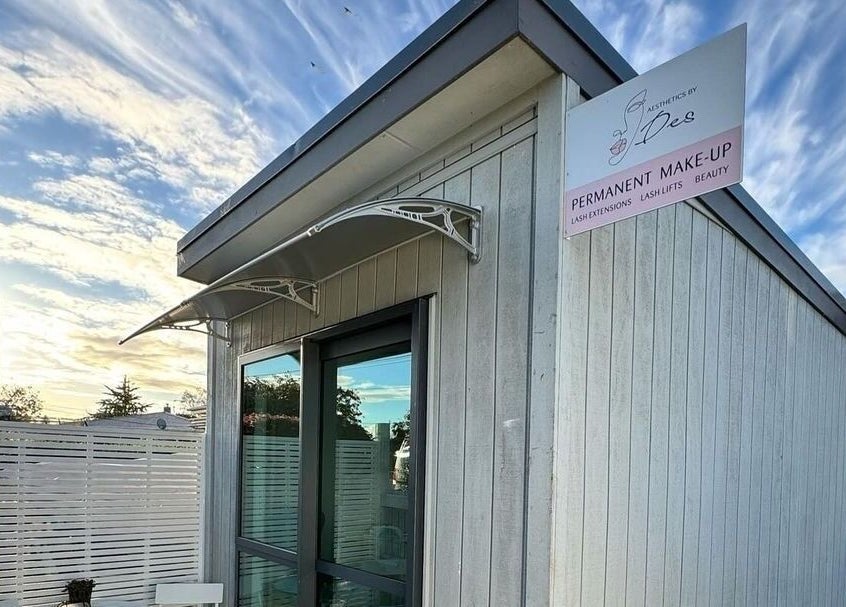 Exterior view of Aesthetics by Des, Cambridge, Waikato, NZ, featuring modern wood paneling and signage.