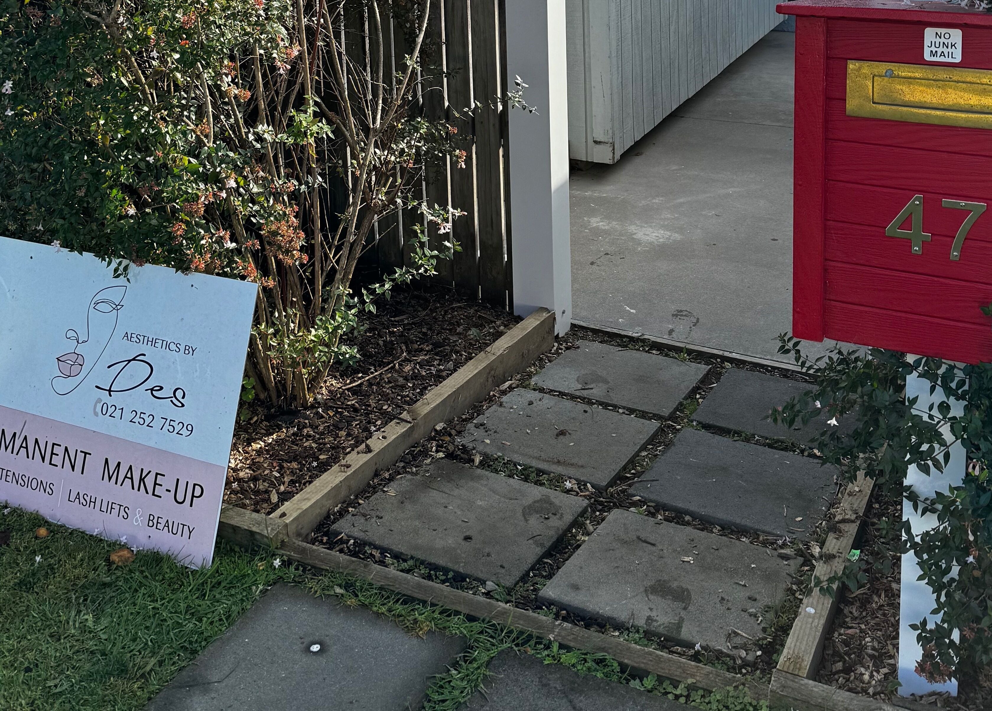 Entrance of Aesthetics by Des with a sign and red mailbox in Cambridge, Waikato, NZ.