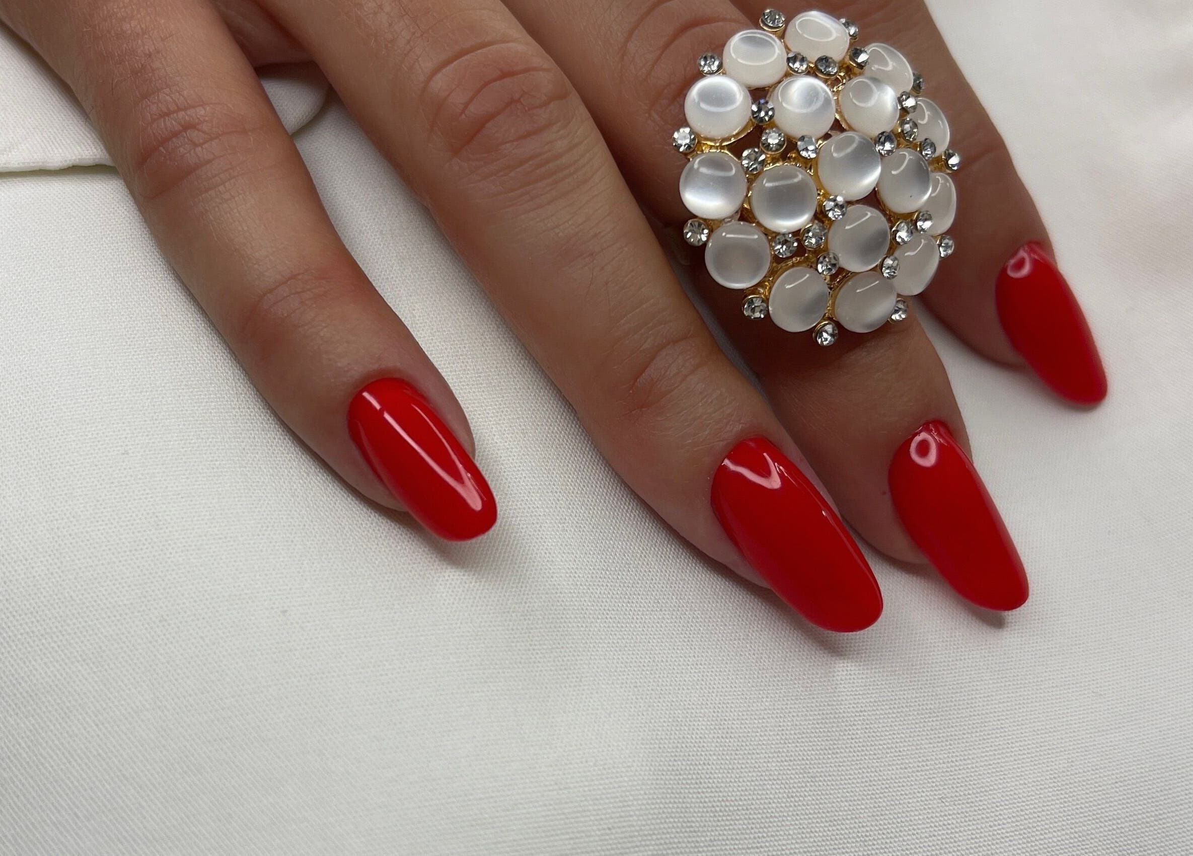 Unghii roșii cu o bijuterie elegantă la Nuvia Massage&Nails, București, București, RO.