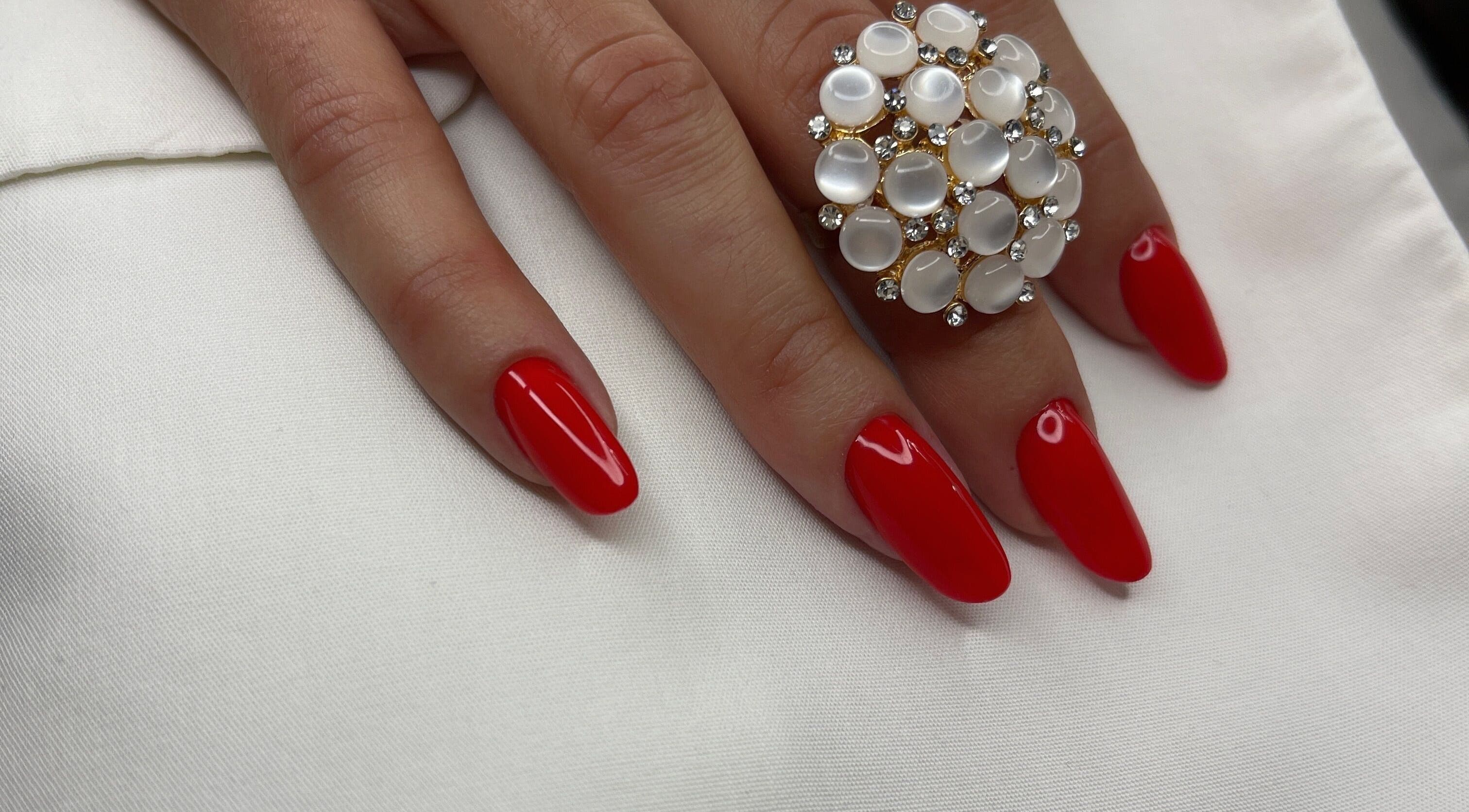 Unghii roșii cu o bijuterie elegantă la Nuvia Massage&Nails, București, București, RO.