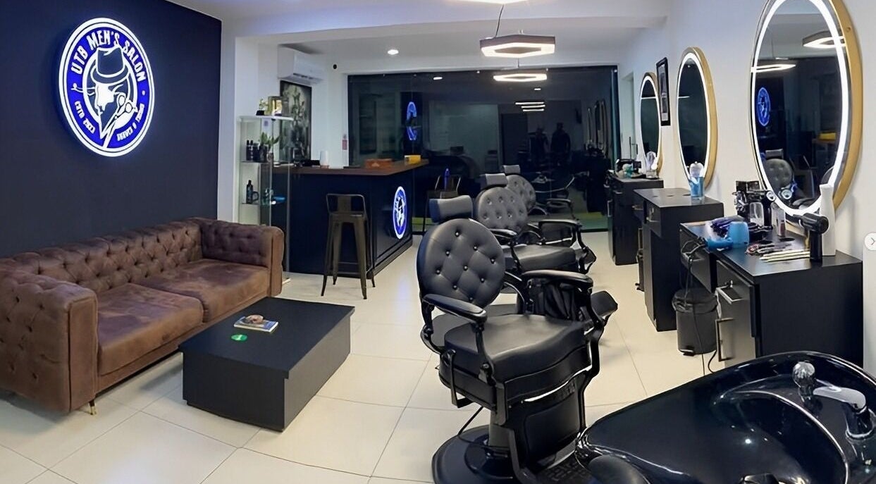 Interior moderno de Utb Men’s Salon en Santiago De Los Caballeros, Santiago, DO con sillas y espejos elegantes.
