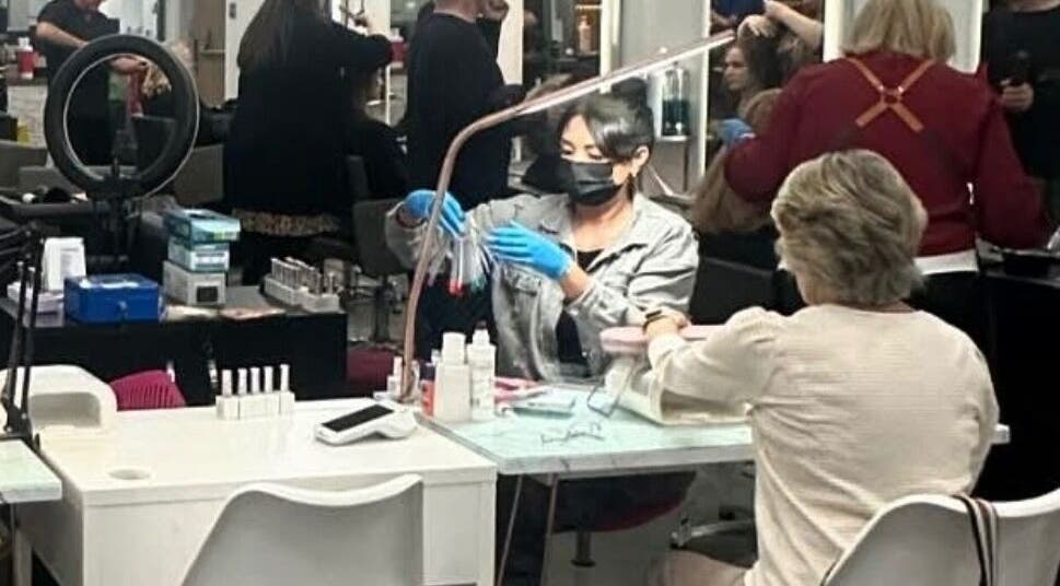 Nail artist working at Nails by Donya in Clarkston, Scotland, GB, providing manicure services in a vibrant salon.