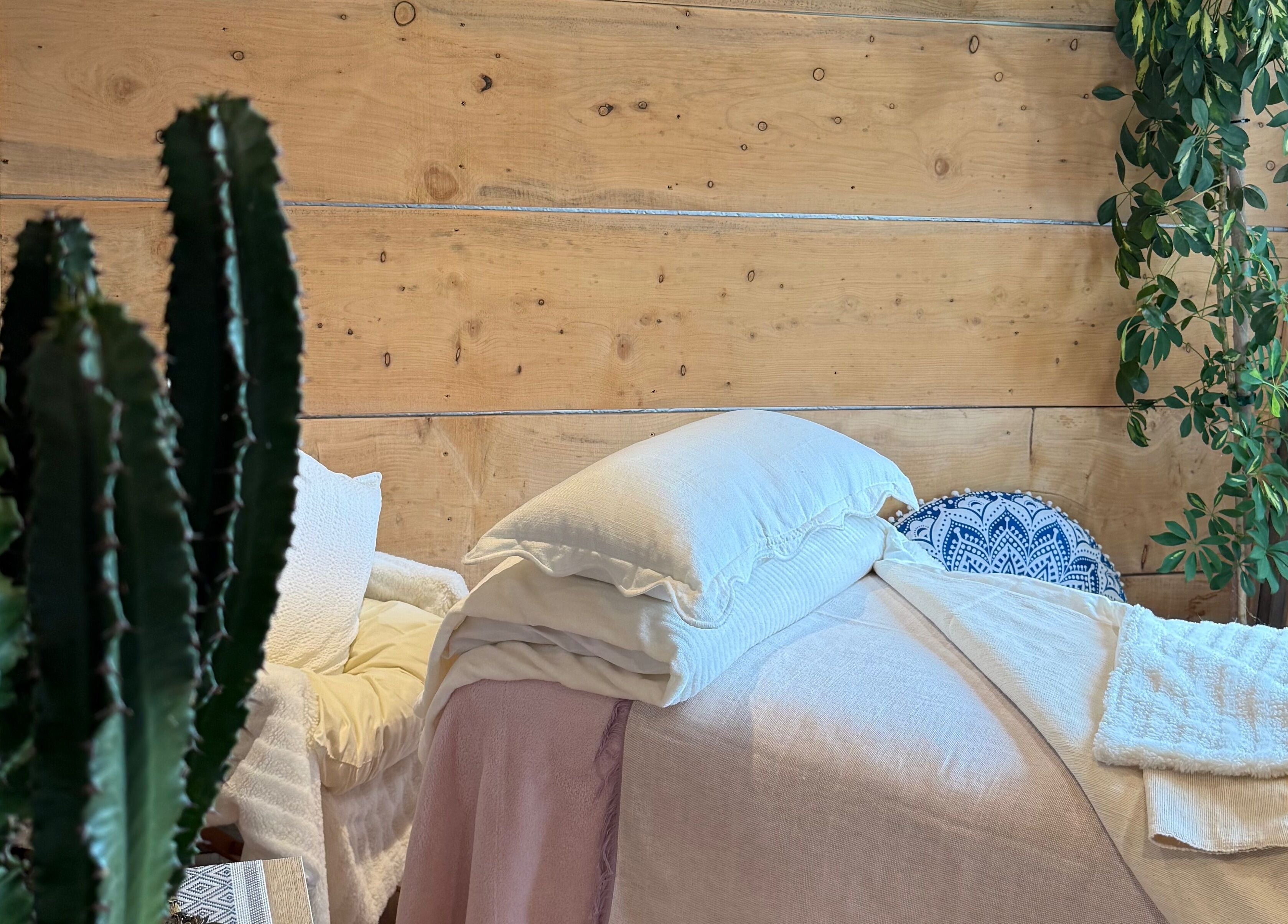 Peaceful massage room at Cedar Cabin Therapies, Holmfirth, England, GB, with cozy bed and lush plants.