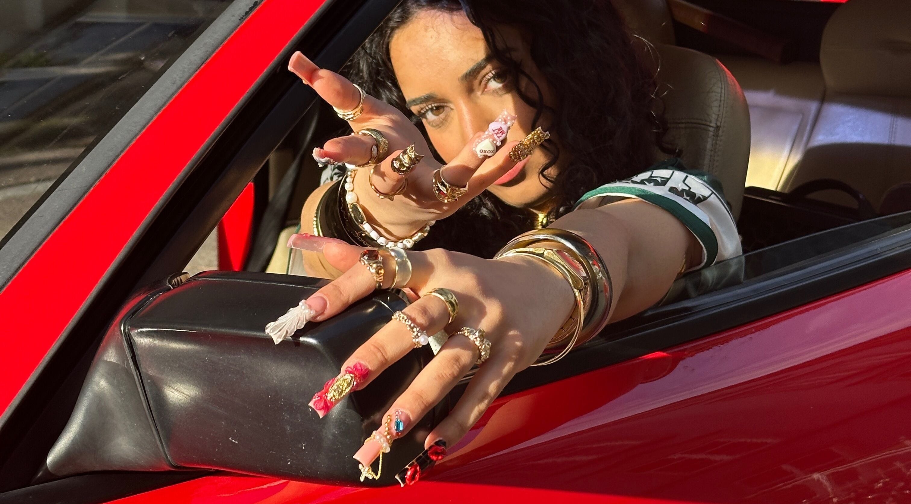 Frau mit kunstvollen Nägeln zeigt Schmuck durch Autofenster bei Babe Cosmetics, Basel, Basel-stadt, CH.